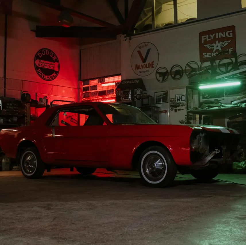 Coche rojo deportivo aparcado en taller mecánico